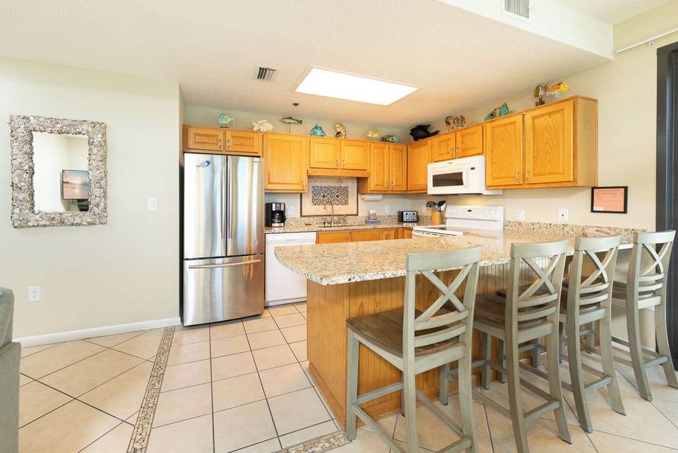 Whip up family favorites at the breakfast bar while chatting and sipping fresh coffee in this kitchen