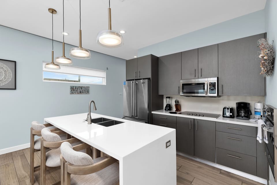 Fully stocked kitchen equipped with stainless steel appliances and a large center island