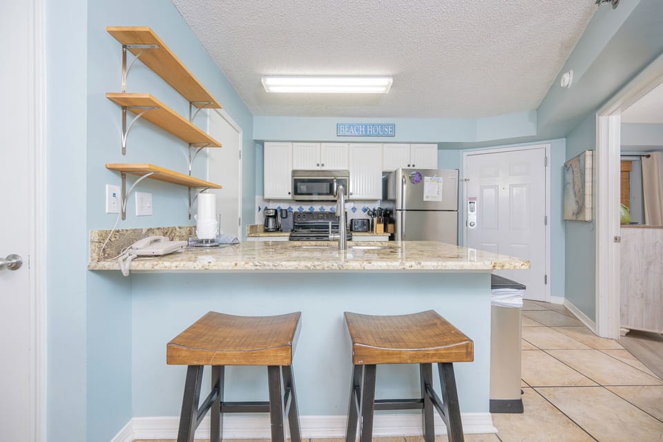 Modern and elegant kitchen featuring stainless appliances, granite countertops, and inviting bar stools for casual dining