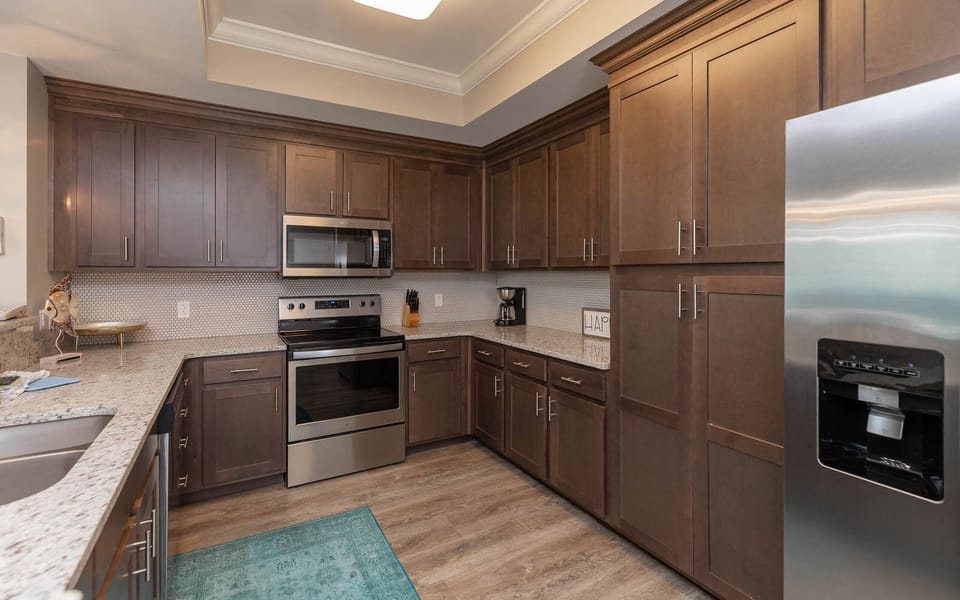 Prepare meals in this kitchen with elegant cabinetry, stainless appliances, and spacious countertops