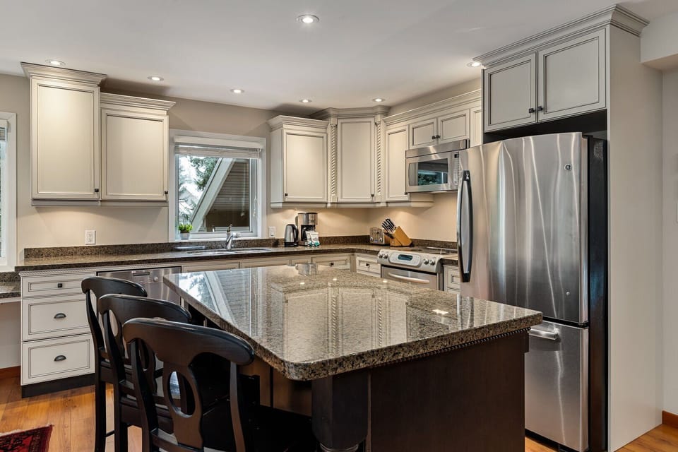 A modern kitchen featuring a granite center island breakfast bar
