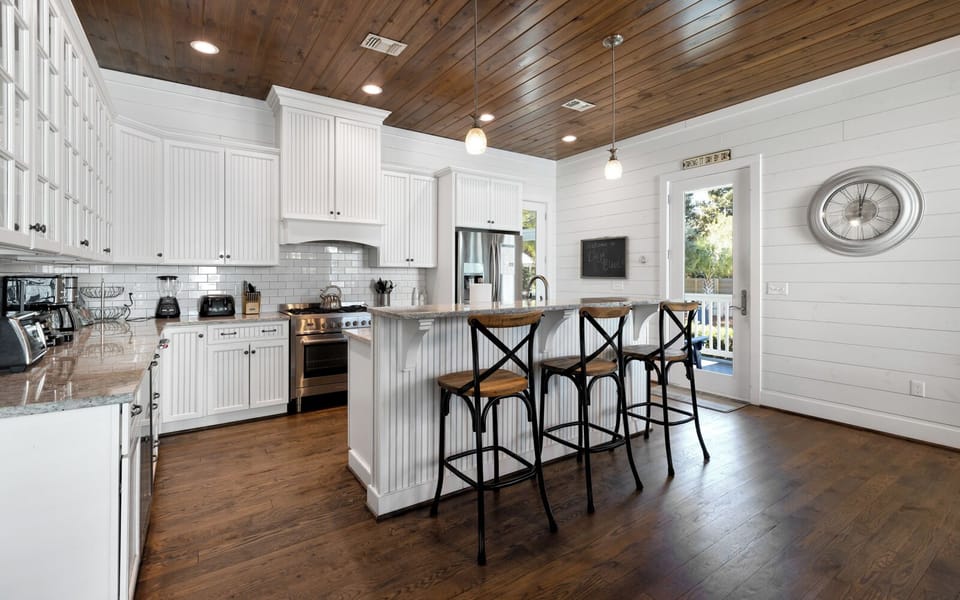 Your spacious farmhouse kitchen features stunning wood-plank ceilings, gleaming granite counters, and a breakfast bar perfect for morning coffee.