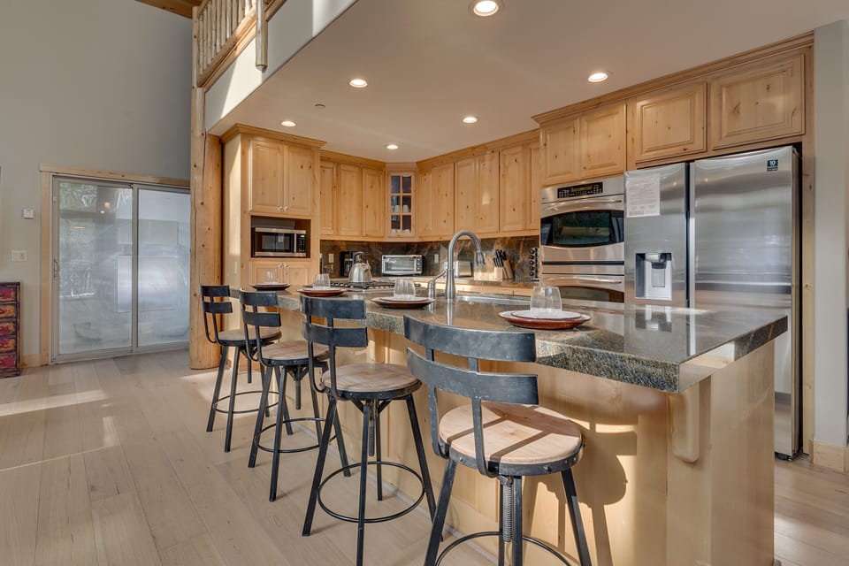 - Gourmet kitchen with stone countertops and breakfast bar  
- Fully equipped with modern appliances for group meals  
- Perfect blend of rustic wood and modern convenience design