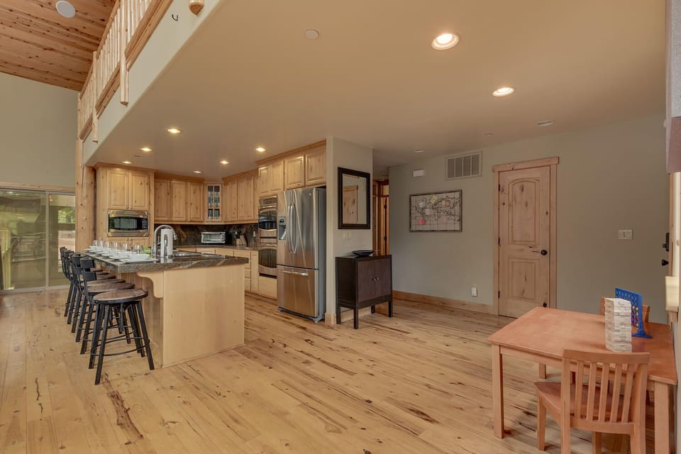 - Open kitchen with island seating and stainless steel appliances  
- Spacious layout ideal for group cooking and social time  
- Natural wood cabinetry adds rustic charm to the mountain stay