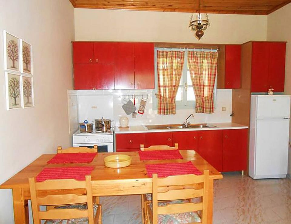 Kitchen zone offers dining table, refrigerator, stove, sink. Bungalow Kefalonia