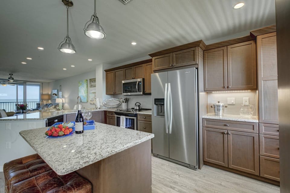 Gorgeous stainless and granite kitchen stocked with plenty of dishes, stemware and appliances.