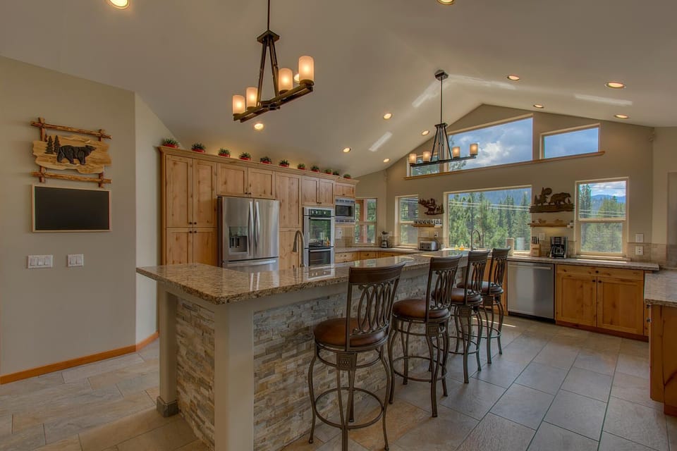 - Modern kitchen with breakfast bar seating  
- Rustic wood cabinetry and elegant lighting fixtures  
- Open layout with scenic mountain views outside
