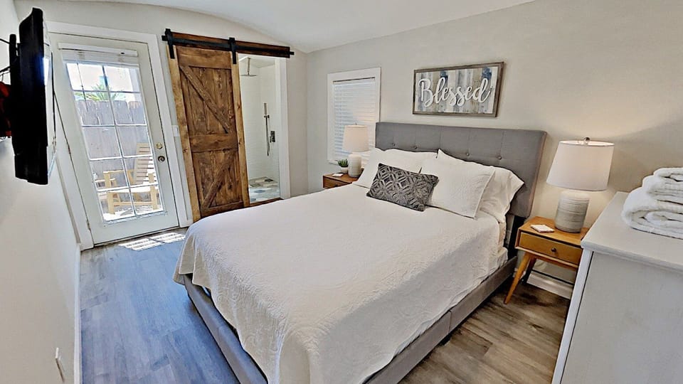 Bedroom with Queen Bed, TV, and Downtown view Patio