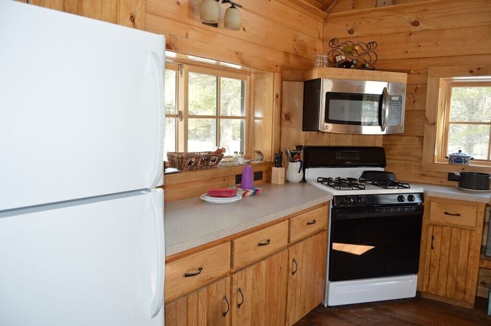 Kitchen view of microwave, stove and refrigerator/freezer