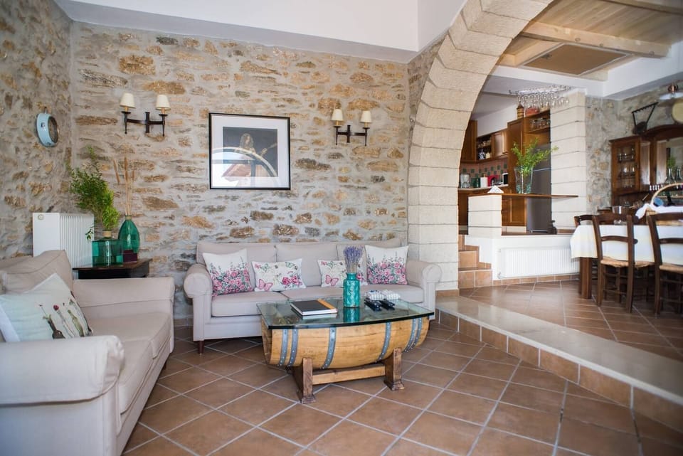 The living and indoor dining area are divided by a traditional stone arch