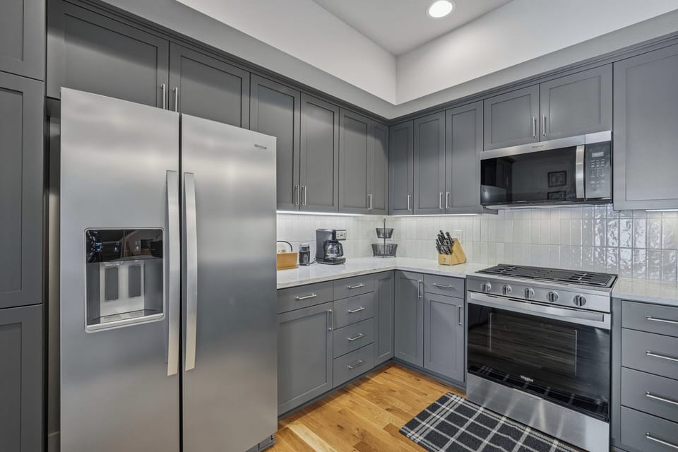 This modern kitchen features sleek stainless appliances, ample cabinetry, and elegant marble countertops—your perfect space for preparing meals and creating culinary memories during your stay.