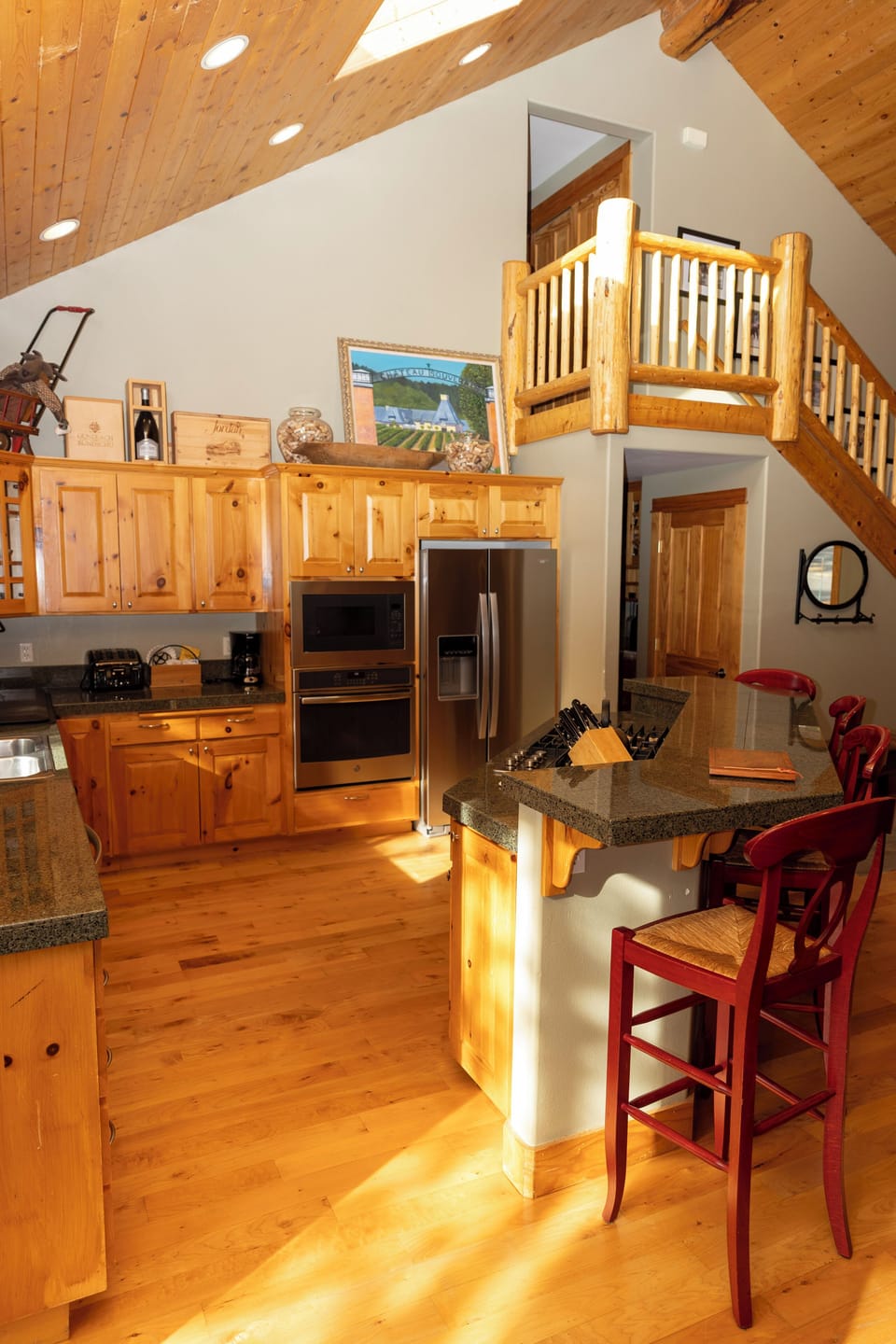 Your fully equipped kitchen features stainless appliances and granite counters, perfect for cooking meals under soaring wood ceilings.