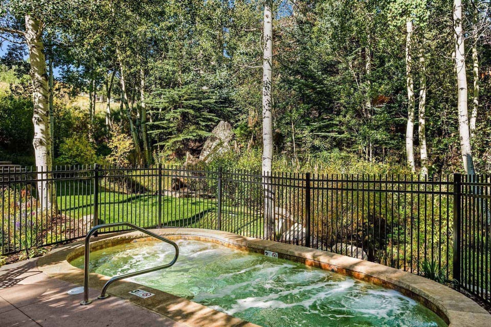Enjoy the year round hot tub at Interlude nestled in a wooded area of the property.