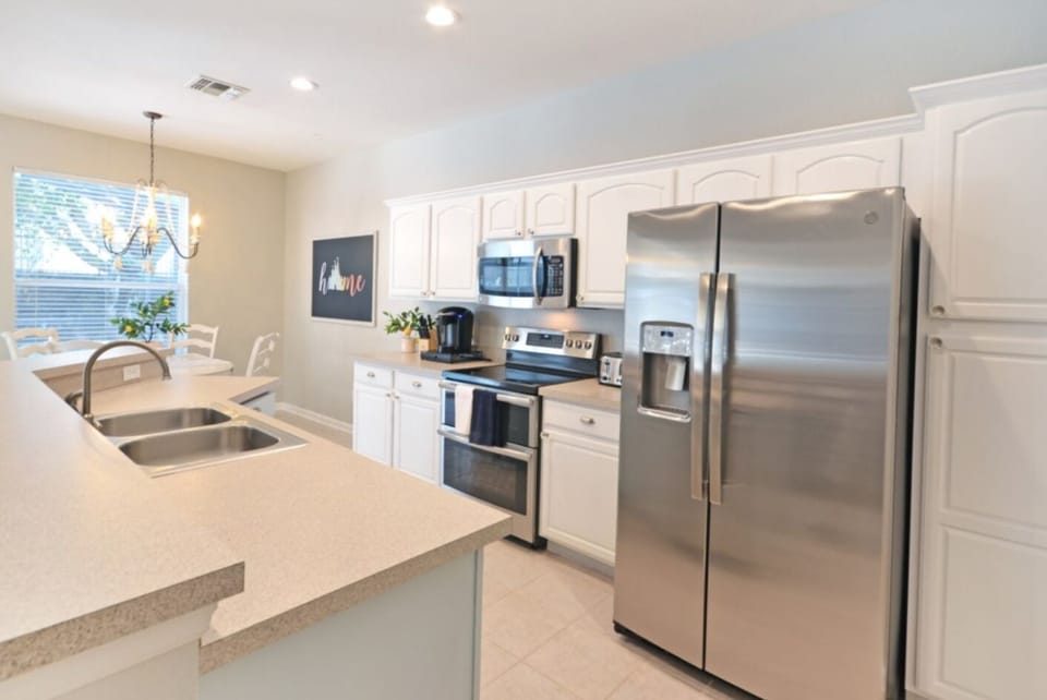 Fully stocked kitchen with new appliances, place settings and silverware