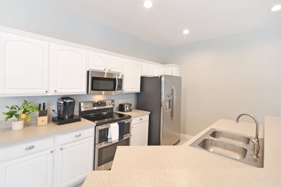 Fully stocked kitchen with new appliances, place settings and silverware