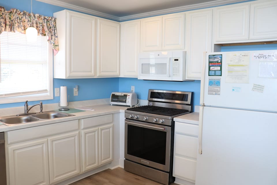 Your bright, fully-equipped kitchen features everything for cooking meals, with cheerful blue accents and modern appliances for your convenience.