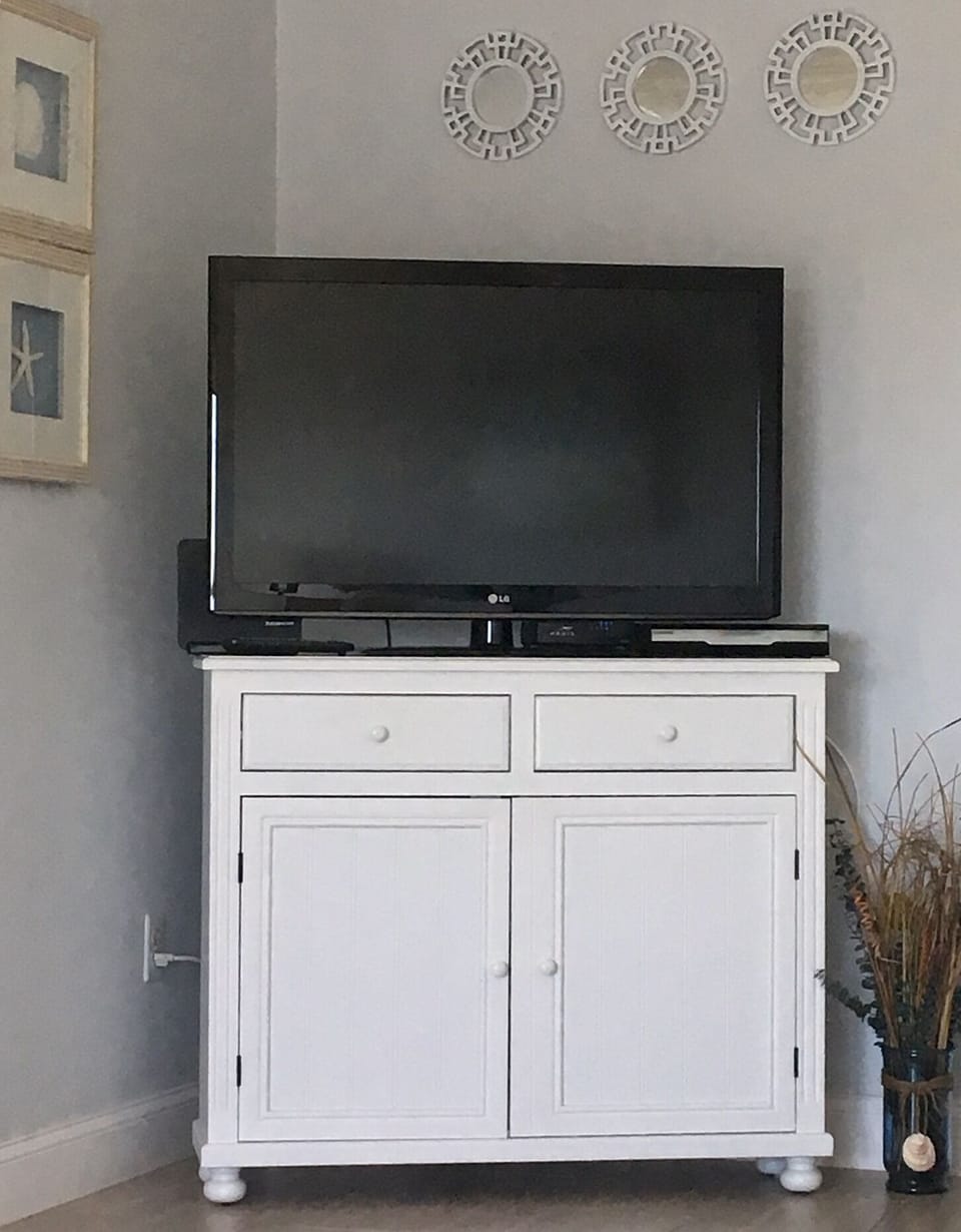 Smart TV sits on cabinet that holds multiple games & cards for family fun!