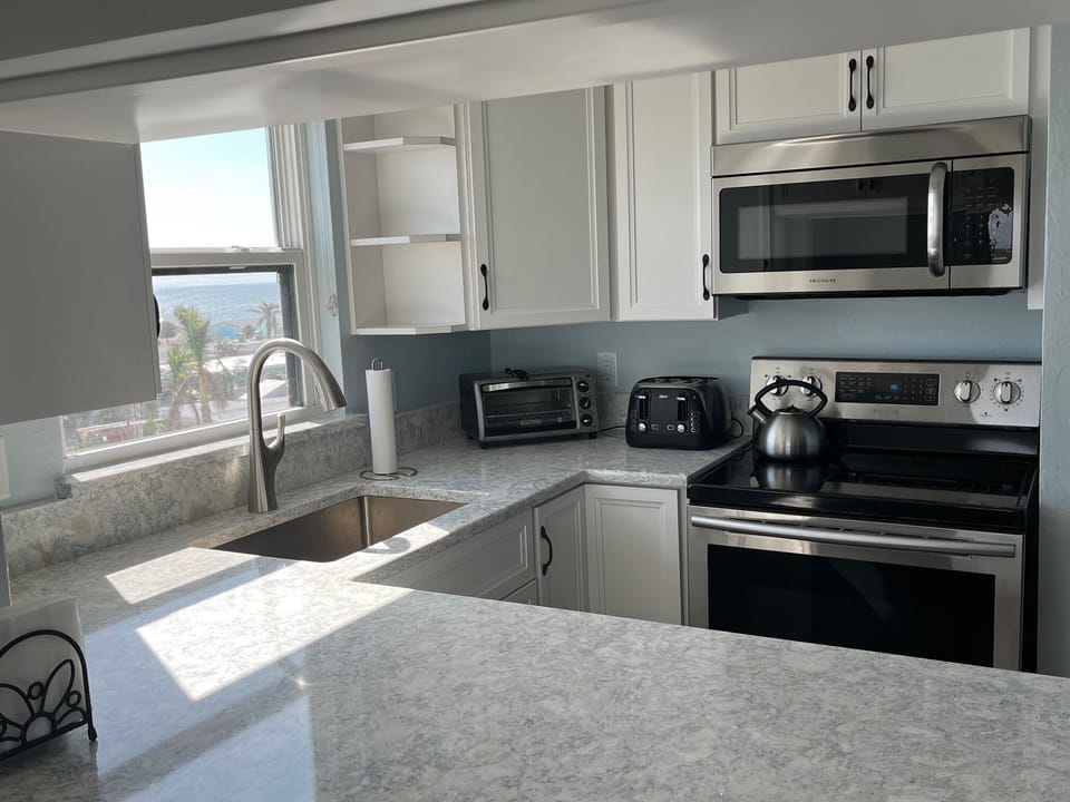 Bright new kitchen features beachy quartz countertops and Gulf views!