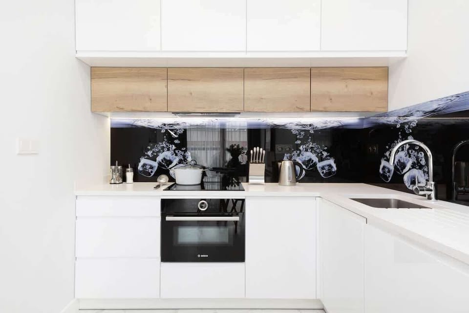 Another view of the modern kitchenette with white cabinets and a clean design, showing a well-organized layout.