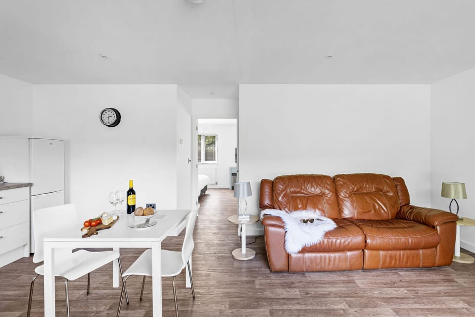 Dining table, sofa and TV in open plan living area - The clover Lodge