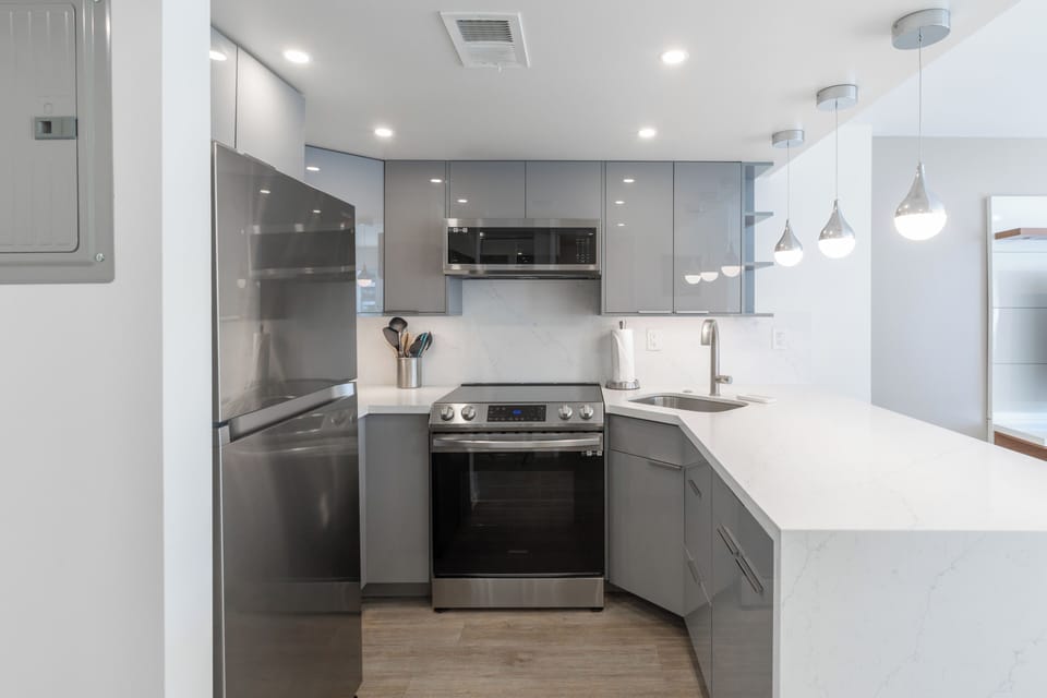 Stainless steel appliances with sleek glossy cabinetry