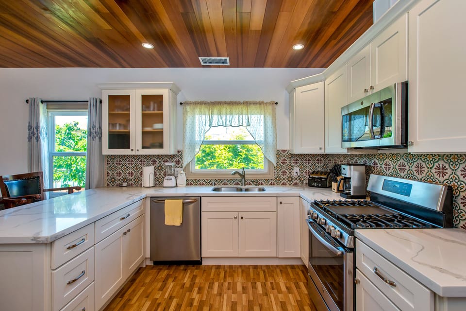 Kitchen with gas stove, built in microwave oven, quartz countertop, dishwasher.