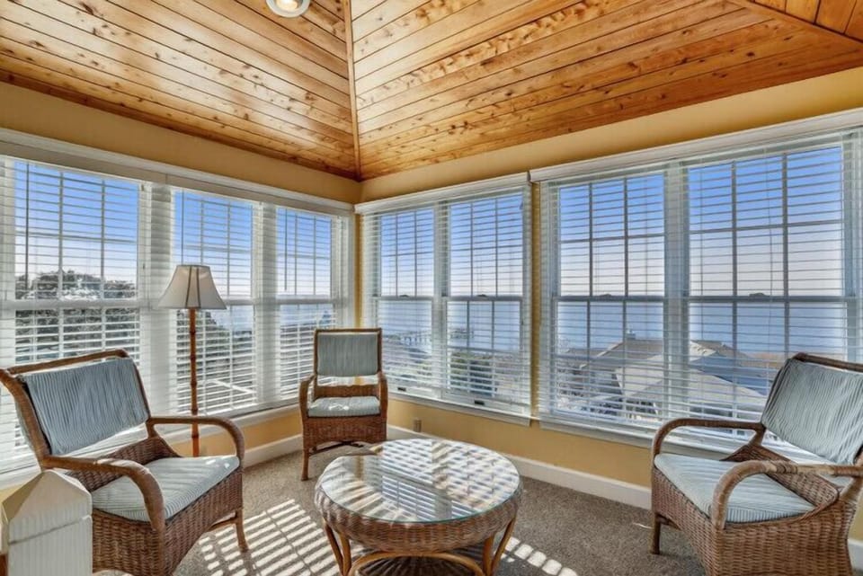 Settle into this sunlit corner with your morning coffee and watch the waves dance across the water through floor-to-ceiling windows that frame endless waterfront views.