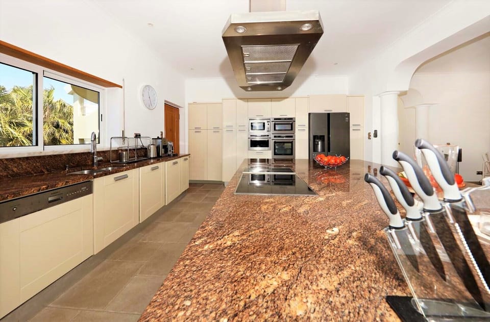 Open plan kitchen with several ovens and appliances