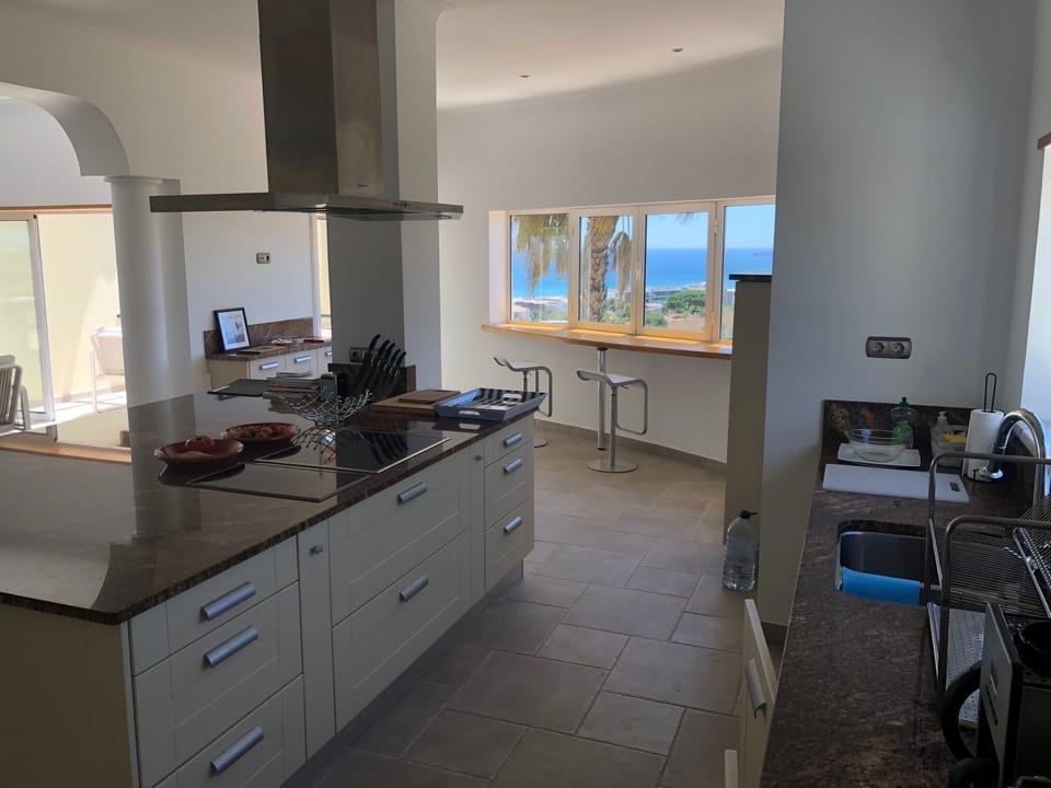 Open plan kitchen  with view to wooden bar and the city of Lagos