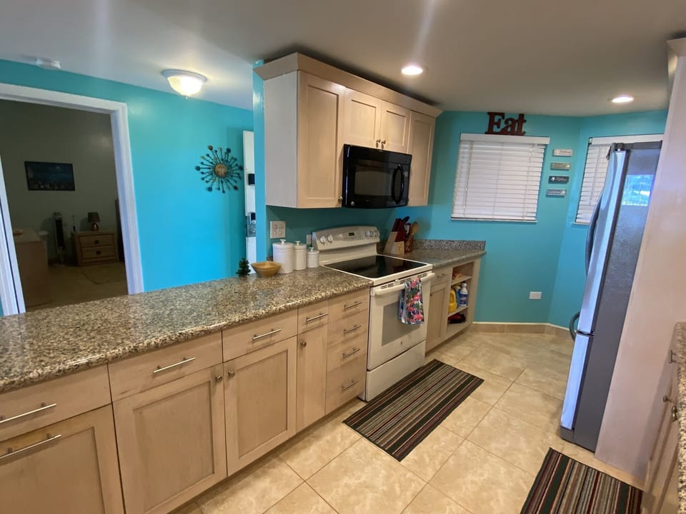 Kitchen with stackable washer and dryer on other side of the fridge