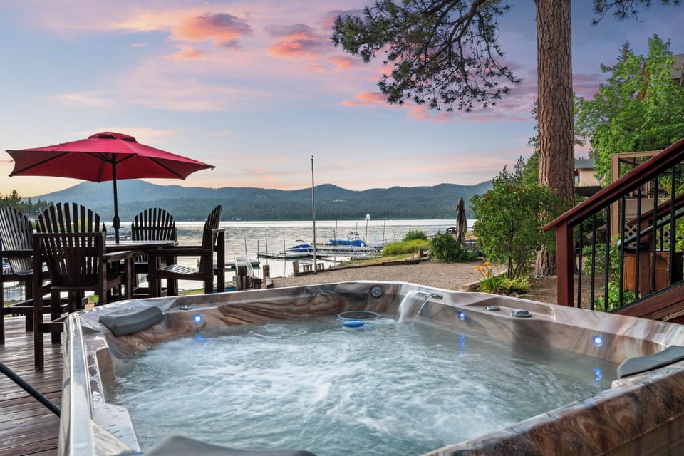 backyard - Awesome lakefront backyard with sun loungers, dock, deck, private hot tub, BBQ, and comfy seating!