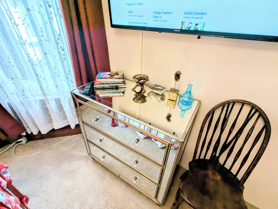 Room 2 has a queen bed, TV, dresser, window, bedside tables, lamps, and chair.