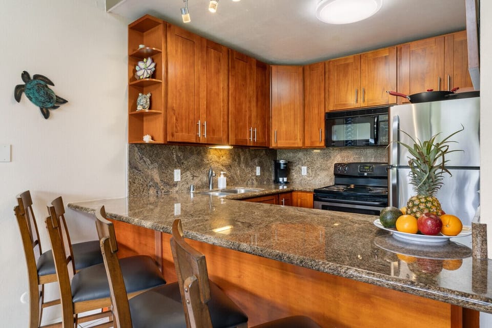 Warm wood-trim kitchen w/ granite counters ready for shared meals.