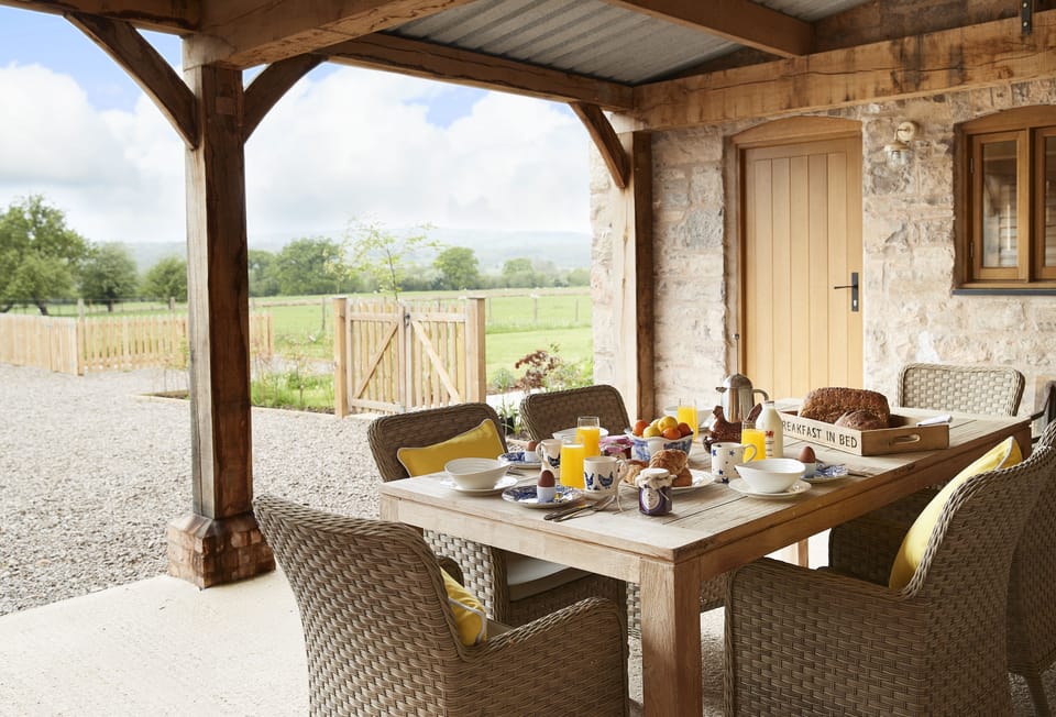 The garden room, a distinctive outdoor space with large dining table and rattan chairs to take in the lovely sunsets