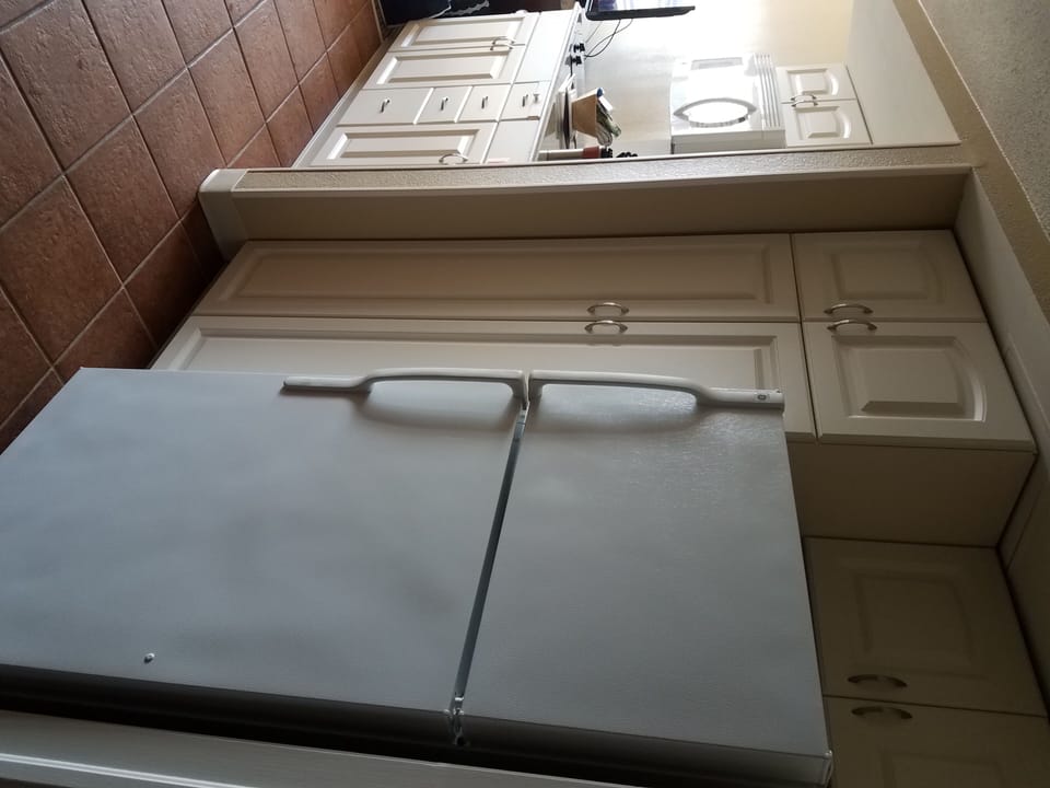 Hallway showing small kitchen area, microwave, and refrigerator