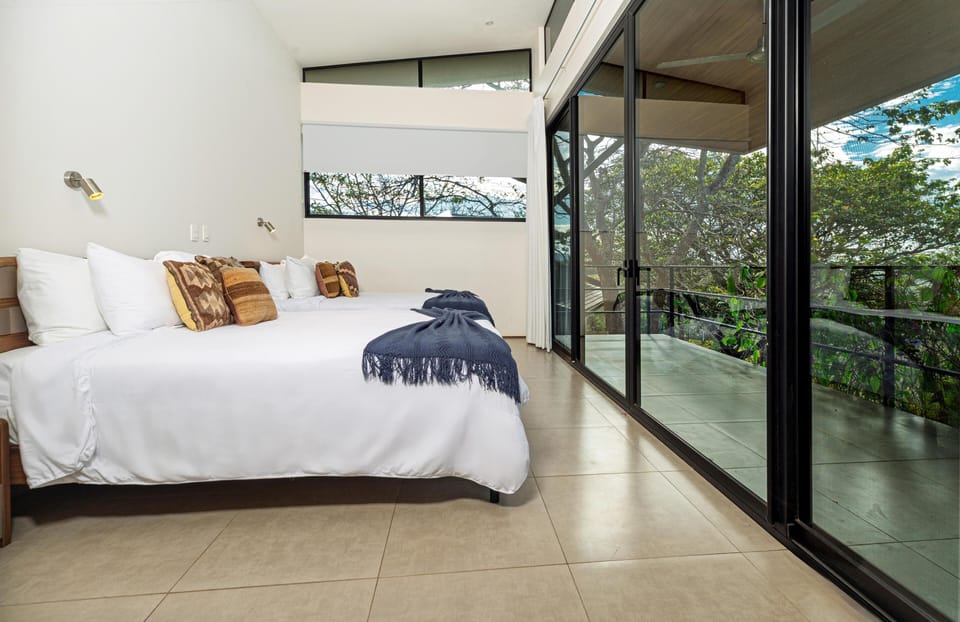 Bright bedroom with floor-to-ceiling windows and scenic views