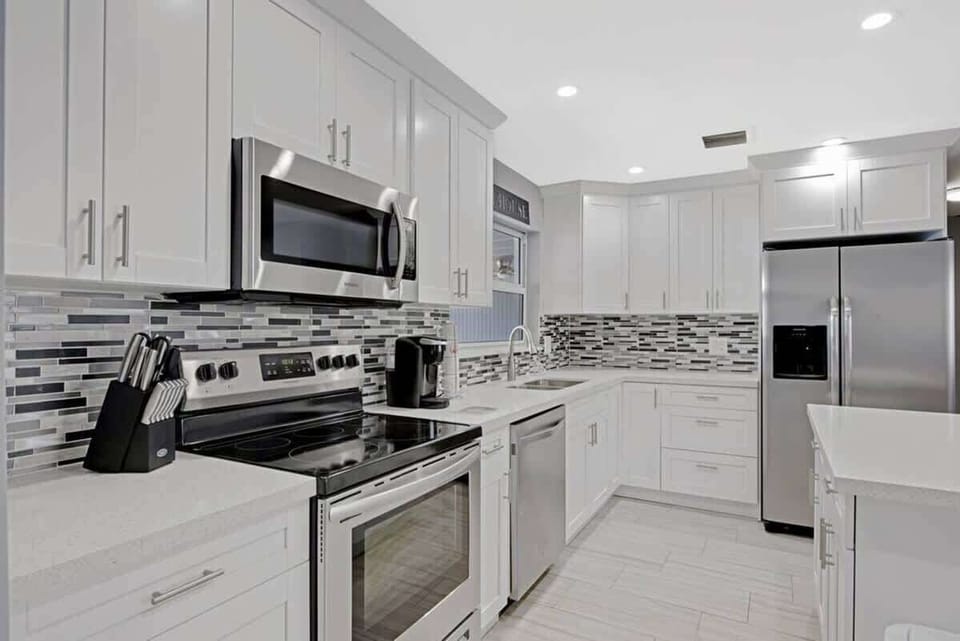 The kitchen is stocked with a full set of appliances including basic kitchen utensils. 