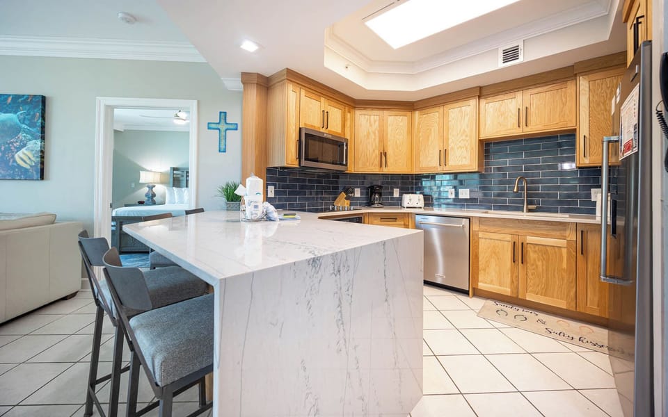 Prepare meals in this kitchen with elegant cabinetry, stainless appliances, and stylish backsplash