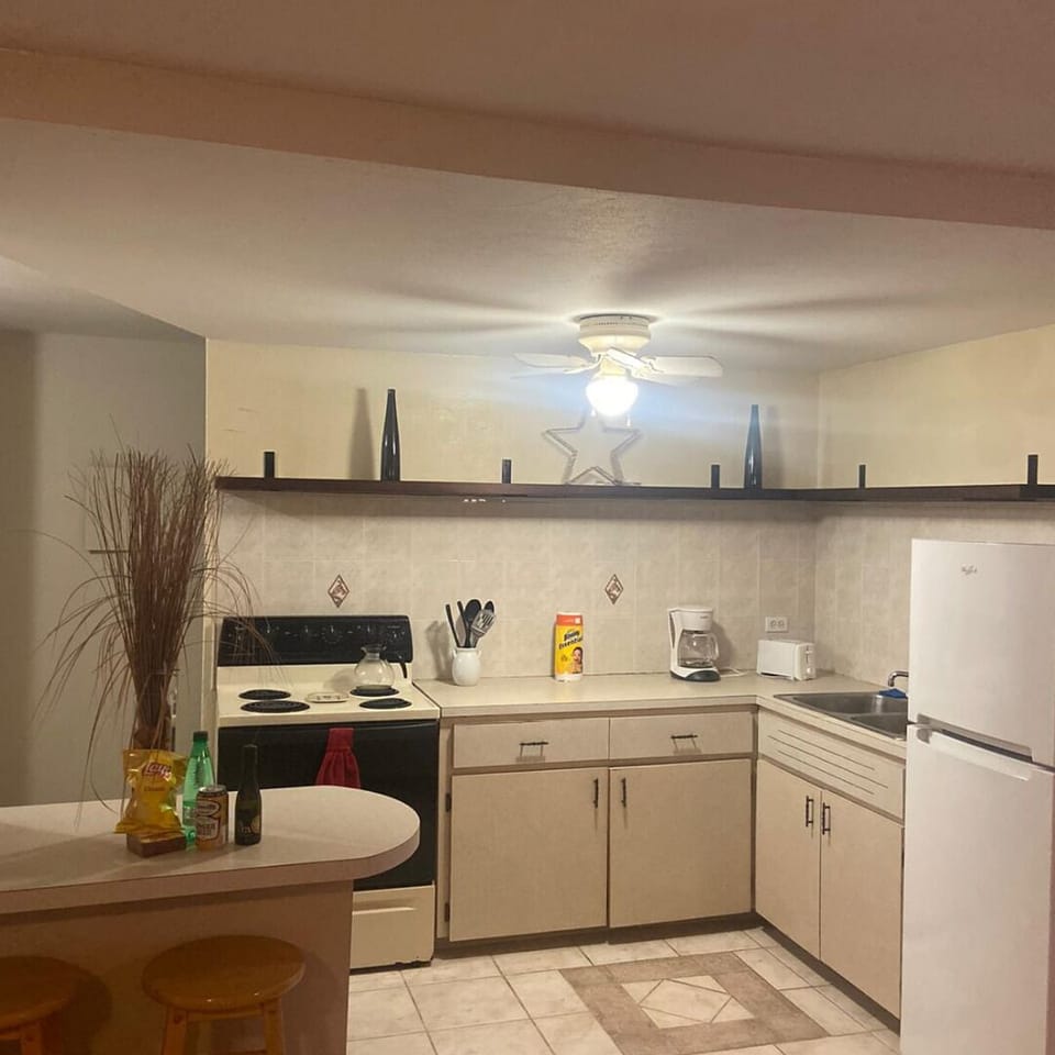 kitchen with barstool-style seating, oven range, fridge/freezer, and utensils