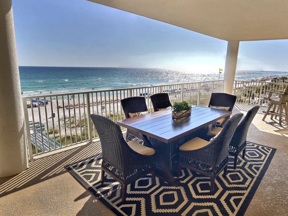 Spacious balcony deck dining overlooking the water and directly on the beach.