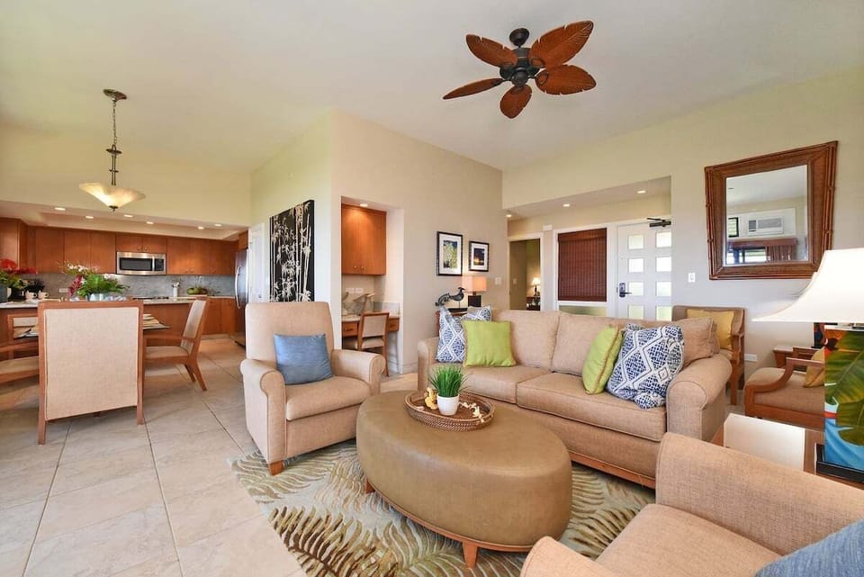 Bright living room with sleeper sofa, flat-screen TV, and open layout flowing seamlessly into the dining and kitchen areas.