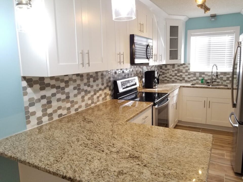 Modern kitchen with granite countertops and stainless steel appliances.
