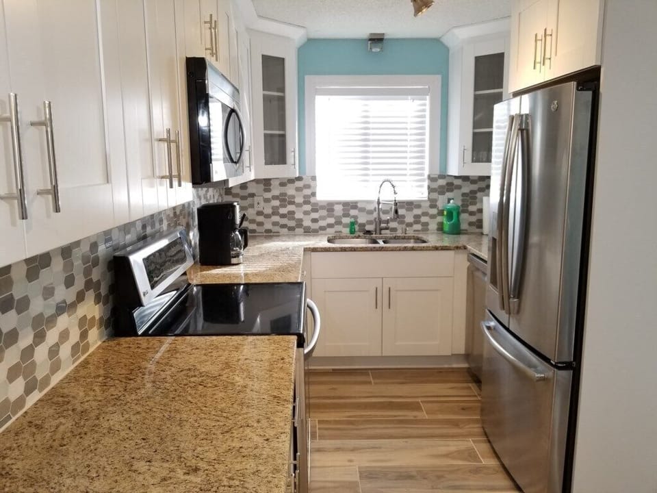 Modern kitchen with stainless steel appliances and granite countertops.