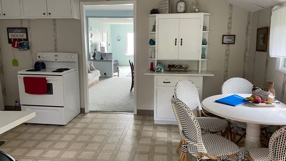 View of kitchen to living room. Large kitchen with cabinet, stove, breakfast table.