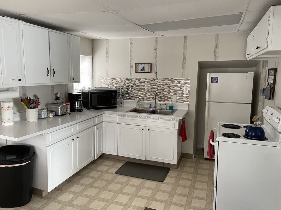 View of kitchen with fridge/freezer, stove/oven, cabinets and vanity and amenities.