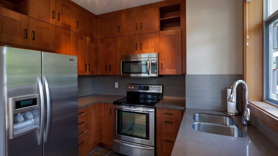 - Modern kitchen with stainless-steel appliances and wooden cabinetry  
- Fully equipped for home-cooked meals during your mountain stay  
- Bright and functional space designed for comfort and convenience  
