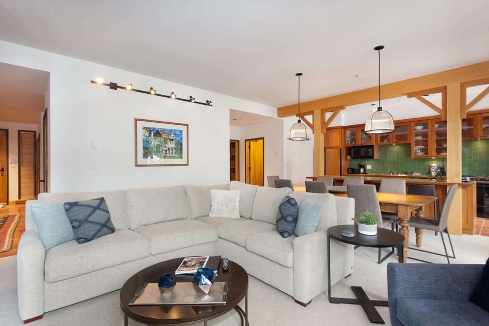 - Spacious living room with plush sectional sofa and cozy fireplace ambiance  
- Open layout ideal for après-ski relaxation and mountain view lounging  
- Modern touches blend comfort and warmth in this Whistler retreat