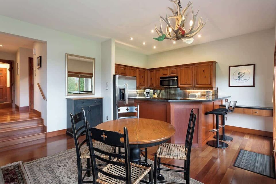 - Inviting dining area beside the kitchen with rustic wood accents  
- Charming chandelier adds a cozy alpine touch to every meal  
- Great for family dinners or morning coffee before skiing  