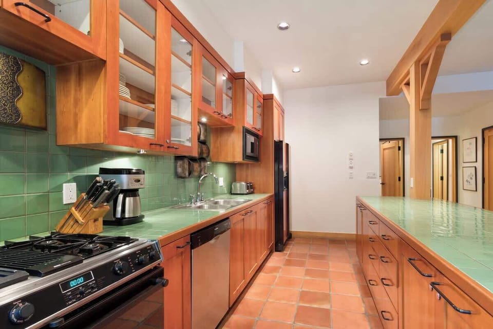- Fully equipped kitchen with warm wood cabinetry and green tile accents  
- Stainless steel appliances and plenty of counter space for easy meal prep  
- Ideal setup for group cooking and après-ski dining  