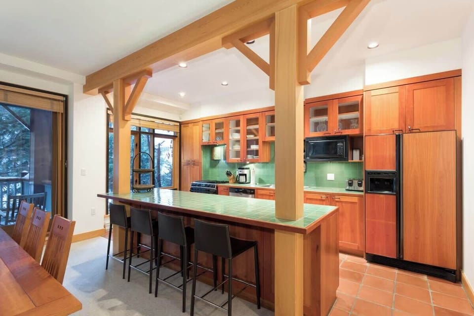 - Spacious kitchen and dining area perfect for family meals  
- Long breakfast bar and natural wood beams highlight mountain charm  
- Opens to outdoor deck for fresh mountain air and gatherings  